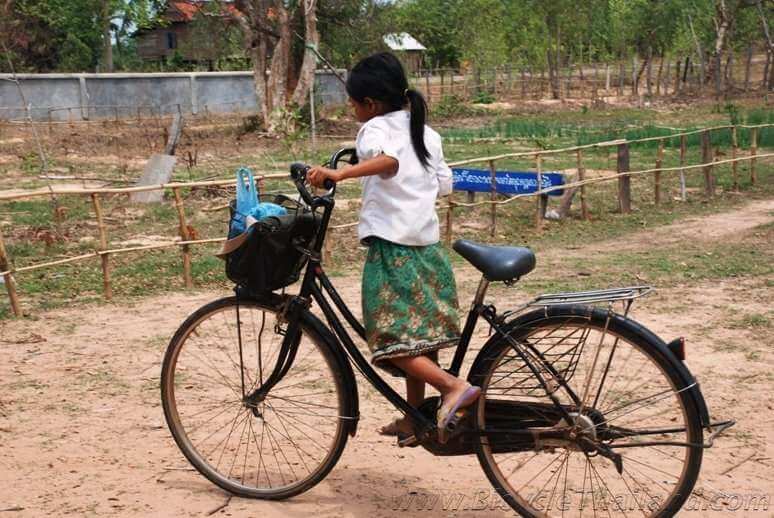Small Cambodian girl on bicycle too big for her